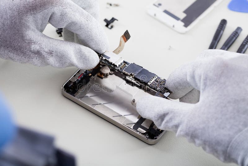 Téléphone de Repairing Broken Mobile de technicien photographie stock Téléphone de Repairing Broken Mobile de technicien photographie stock