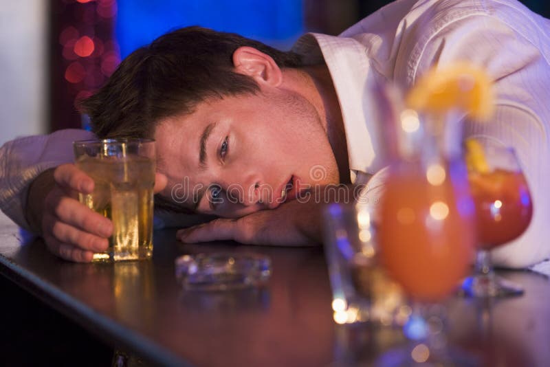 Tête de repos ivre de jeune homme sur le compteur de bar photos libres de droits Tête de repos ivre de jeune homme sur le compteur de bar photos libres de droits