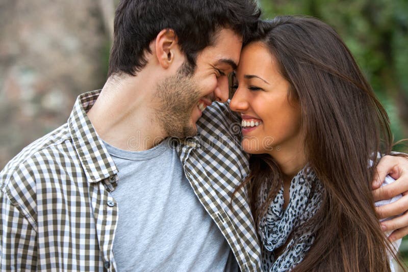 Young couple laughing with heads together outdoors. Young couple laughing with heads together outdoors.