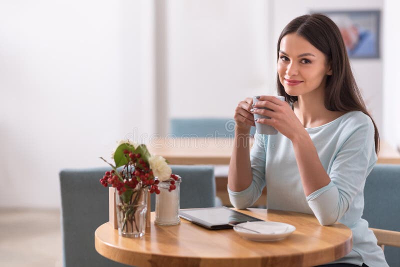 Título: Mujer hermosa encantadora feliz que se relaja en una cafetería imágenes de archivo libres de regalías Título: Mujer hermosa encantadora feliz que se relaja en una cafetería imágenes de archivo libres de regalías