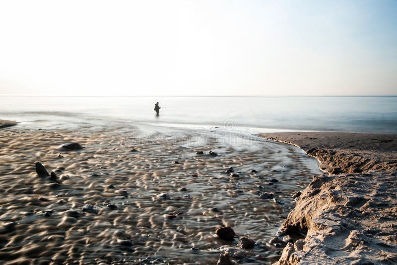 Töm stranden på den Östersjön lång exponering eller fiskaren arkivbilder