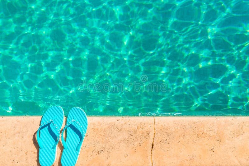 Turquoise flip flops at the edge of the pool. Turquoise flip flops at the edge of the pool