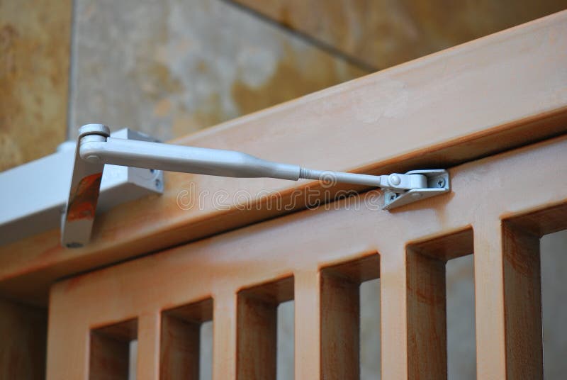 A photo taken on a door closer installed on a wooden door. A photo taken on a door closer installed on a wooden door.