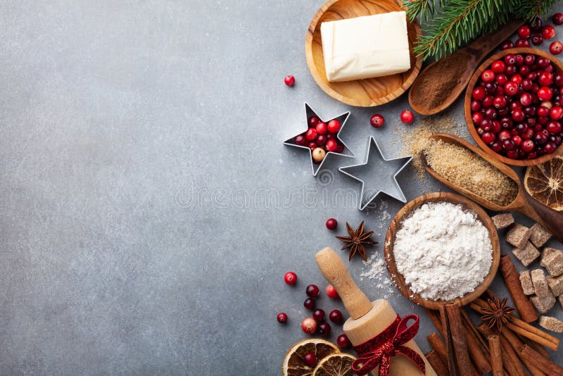 Tło piekarnicze ze składnikami do pieczenia świątecznego Mąka, cukier brązowy, masło, żurawina i przyprawy na stole