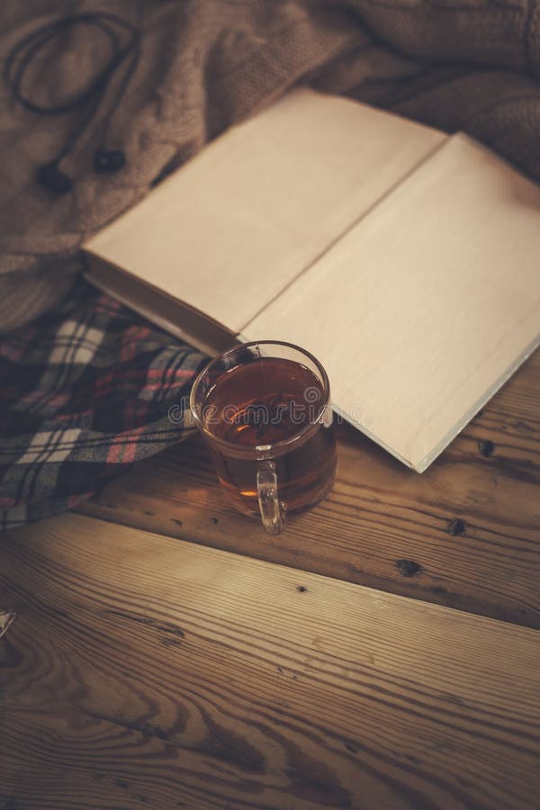 Fall background. Autumn composition with hot tea, book, dry rose flower and knitted sweater. A cup of hot tea, knitted scarf on wooden table. Autumn reading list. Weekend leisure at fall season. Fall background. Autumn composition with hot tea, book, dry rose flower and knitted sweater. A cup of hot tea, knitted scarf on wooden table. Autumn reading list. Weekend leisure at fall season