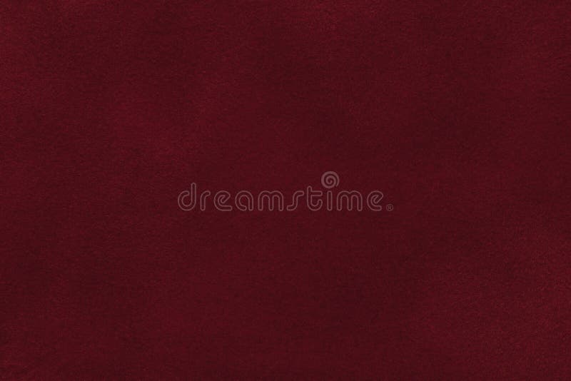 Background of dark red suede fabric closeup. Velvet matt texture of wine nubuck textile. Background of dark red suede fabric closeup. Velvet matt texture of wine nubuck textile.