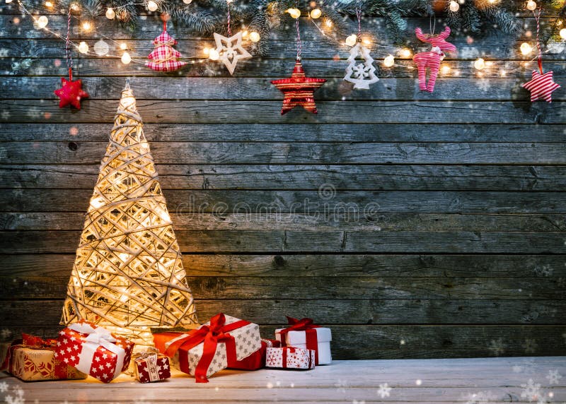 Tło świąteczne z oświetlonym choinką, prezentami i ozdobami