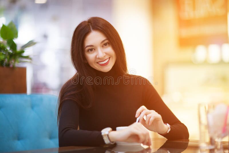 U?miechni?ta kobieta pije kaw? w kawiarni. Portret pi?kna szcz??liwa elegancka kobieta. Moda styl ?ycia zdjęcia royalty free U?miechni?ta kobieta pije kaw? w kawiarni. Portret pi?kna szcz??liwa elegancka kobieta. Moda styl ?ycia zdjęcia royalty free