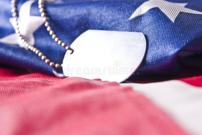 An blank army veteran dogtag set against a flag of the United States. An blank army veteran dogtag set against a flag of the United States.