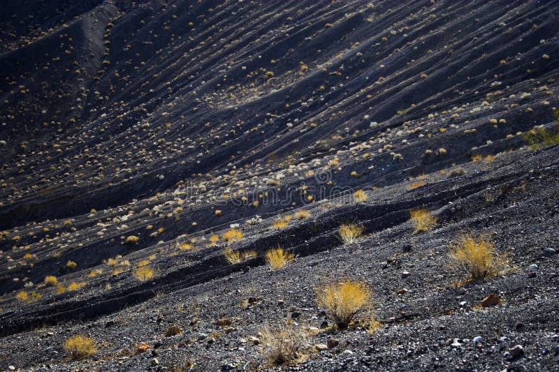 Fragment of black lava and ornage clay and salt mineral deposits in geological formations in Ubehebe Volcano, Death Valley National Park. Sand fragment stock images, royalty-free photos and pictures