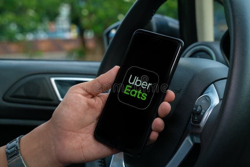 Uber Driver Holding Smartphone in Car. Uber is an American Company ...