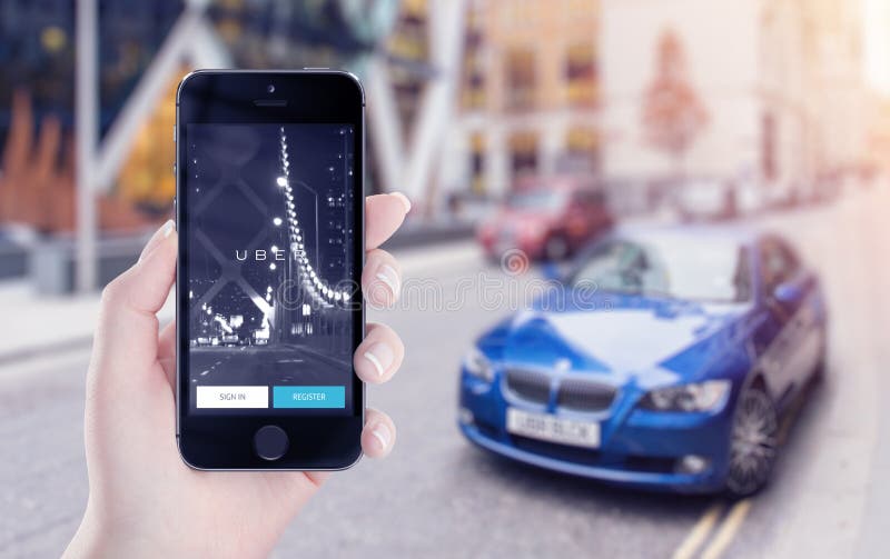 Uber在苹果计算机iPhone显示的应用起动在女性手上 免版税库存图片