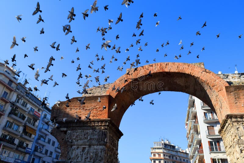Uccelli che sorvolano l'arco di Galerio, Salonicco Grecia fotografia stock Uccelli che sorvolano l'arco di Galerio, Salonicco Grecia fotografia stock