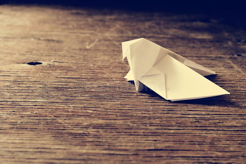 Uccello su una superficie di legno, retro effetto di origami fotografia stock Uccello su una superficie di legno, retro effetto di origami fotografia stock