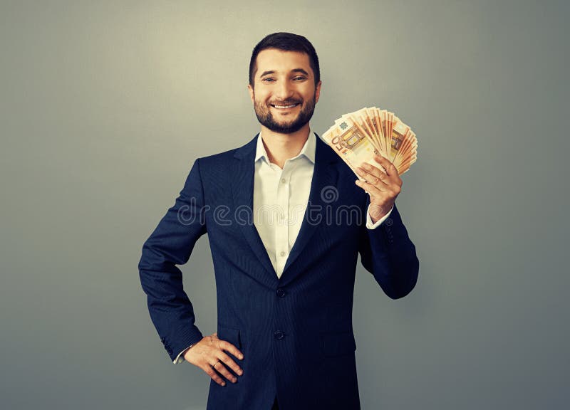 Uccessful biznesmen trzyma papierowego pieniądze zdjęcia royalty free Uccessful biznesmen trzyma papierowego pieniądze zdjęcia royalty free
