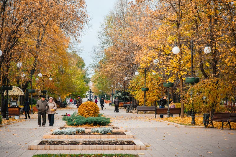 UCRANIA, DONETSK, NOVIEMBRE, 03, 2015: Avenida hermosa del otoño y gente que camina imagen de archivo libre de regalías UCRANIA, DONETSK, NOVIEMBRE, 03, 2015: Avenida hermosa del otoño y gente que camina imagen de archivo libre de regalías