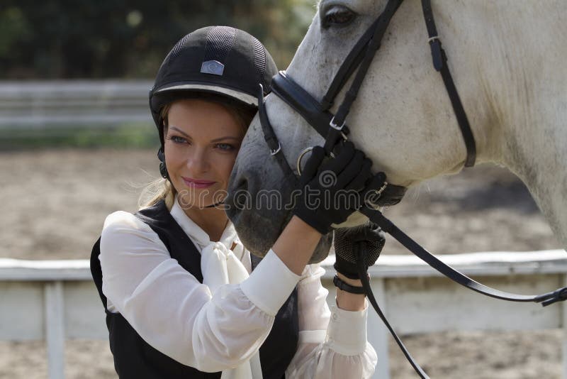 Ucrania, Kiev La muchacha del jinete abraza la cabeza del ` s del caballo foto de archivo libre de regalías Ucrania, Kiev La muchacha del jinete abraza la cabeza del ` s del caballo foto de archivo libre de regalías