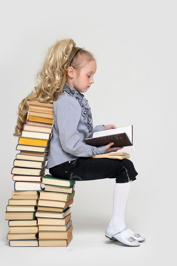 Young schoolgirl and a lot of books. Young schoolgirl and a lot of books