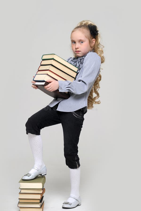 Young schoolgirl and a lot of books. Young schoolgirl and a lot of books