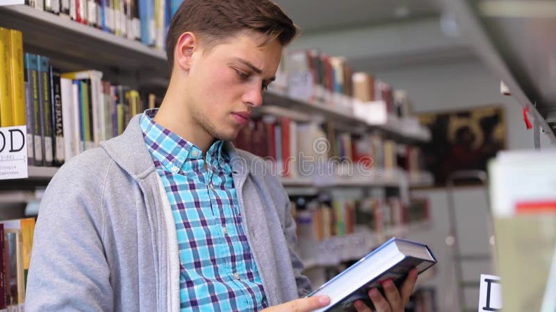 Uczeń Przy biblioteką Mężczyzna Patrzeje książki Na półka na książki