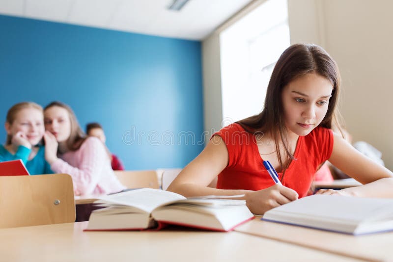 Ucznie plotkuje za kolega z klasy plecy przy szkołą zdjęcie stock Ucznie plotkuje za kolega z klasy plecy przy szkołą zdjęcie stock