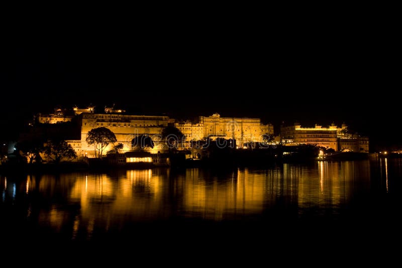 The Udaipur city Palace by night with its reflexion in the lake