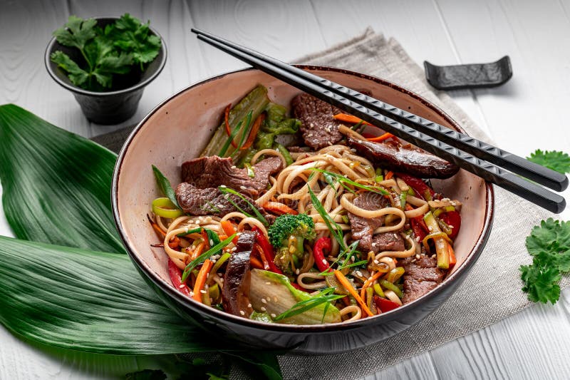 Udon Stir Fry Noodles with Beef Meat and Vegetables in a Plate on White