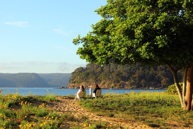 Uferlandschaft im Frühjahr mit Frauen im Ruhezustand lizenzfreies stockfoto Uferlandschaft im Frühjahr mit Frauen im Ruhezustand lizenzfreies stockfoto