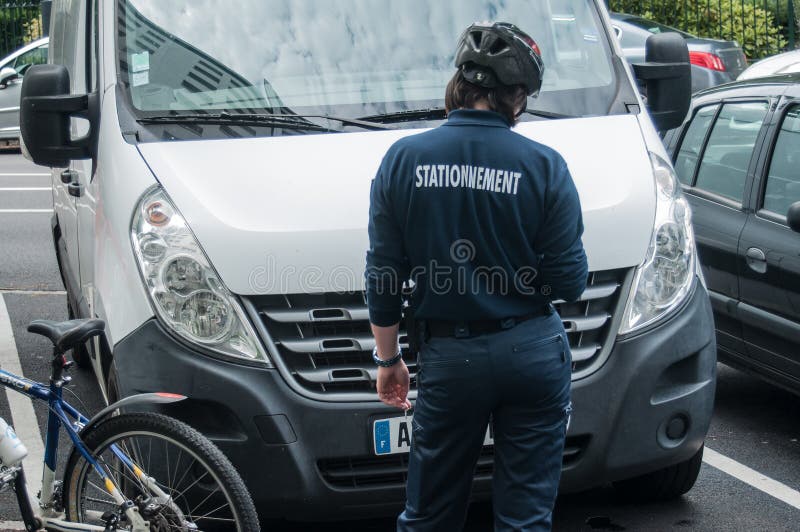 Ufficiale di polizia municipale sulla bicicletta con un rapporto di parcheggio immagini stock libere da diritti Ufficiale di polizia municipale sulla bicicletta con un rapporto di parcheggio immagini stock libere da diritti