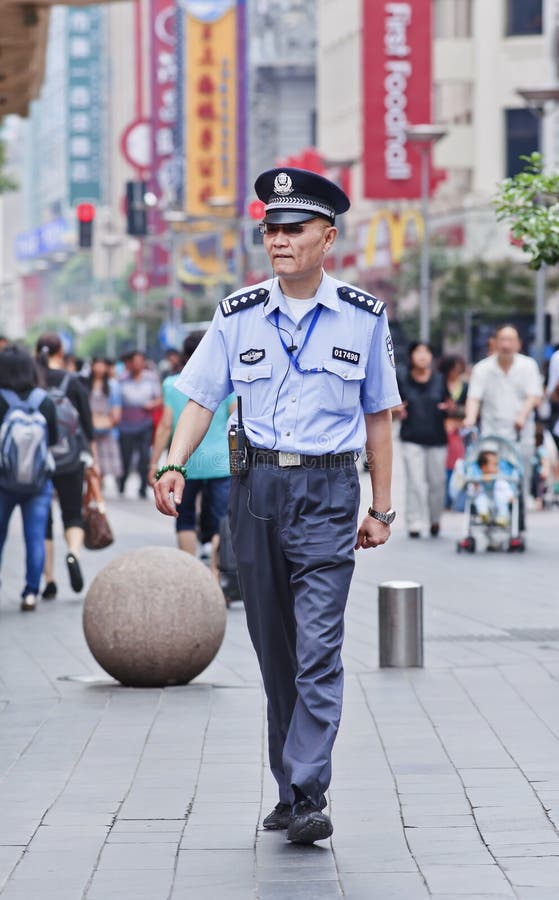 Ufficiale di polizia nel centro urbano, Shanghai, Cina fotografia stock Ufficiale di polizia nel centro urbano, Shanghai, Cina fotografia stock