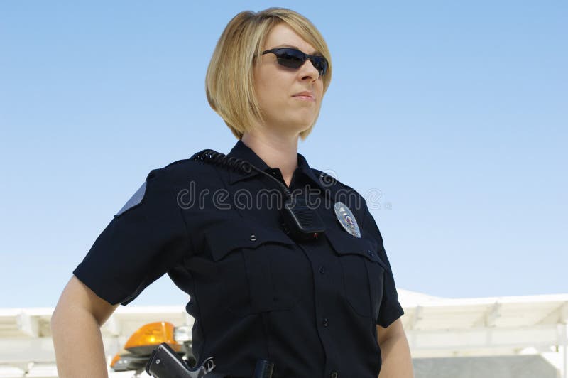 Confident female police officer with sunglasses against clear sky. Confident female police officer with sunglasses against clear sky