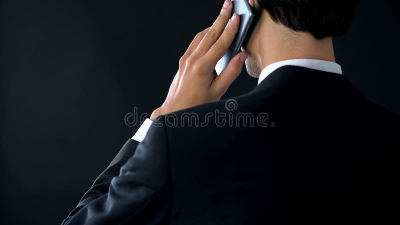 Ufny dyrektor spółki opowiada telefonu widok z powrotem, mianuje partnera spotkania zdjęcie royalty free Ufny dyrektor spółki opowiada telefonu widok z powrotem, mianuje partnera spotkania zdjęcie royalty free