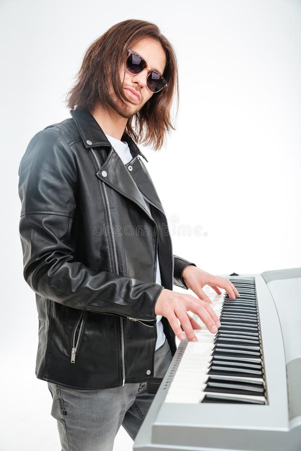Ufny młody keyboardzista stoi i bawić się na syntetyku w okularach przeciwsłonecznych fotografia royalty free Ufny młody keyboardzista stoi i bawić się na syntetyku w okularach przeciwsłonecznych fotografia royalty free