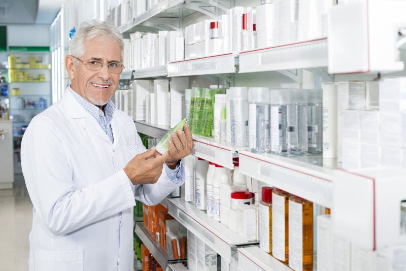 Ufny Starszy chemika mienia produkt W aptece zdjęcie stock Ufny Starszy chemika mienia produkt W aptece zdjęcie stock