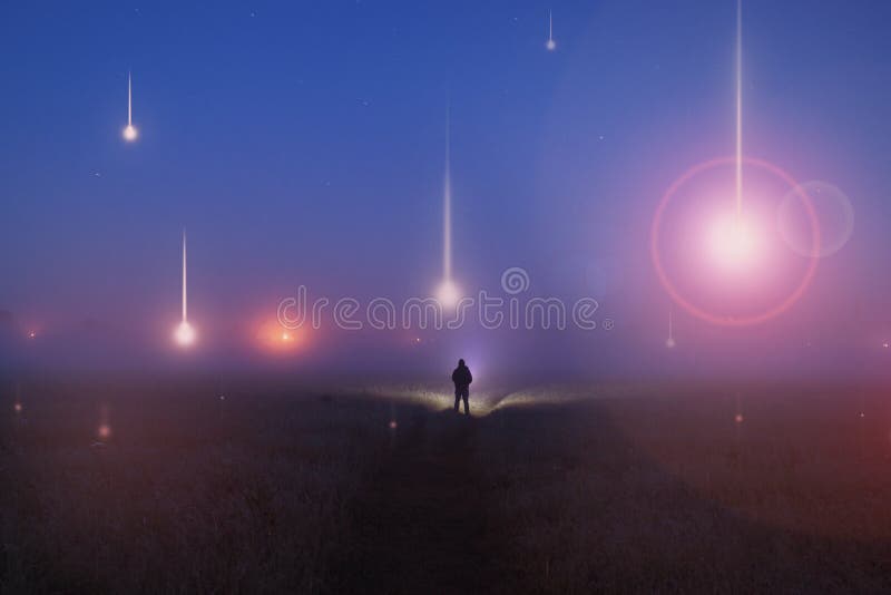 UFO concept. Glowing orbs, floating above a misty field at night. With a silhouetted figure looking at the lights