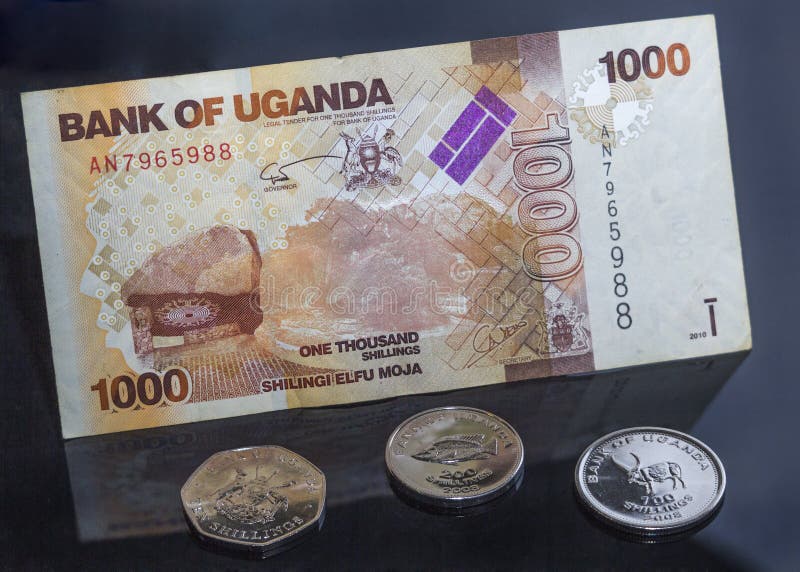 Uganda money, coins and bills, black background