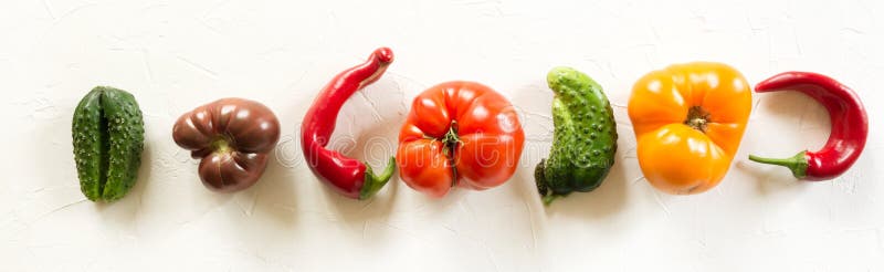 Ugly organic colorful tomato, pepper, cucumber on white concrete table stock photo