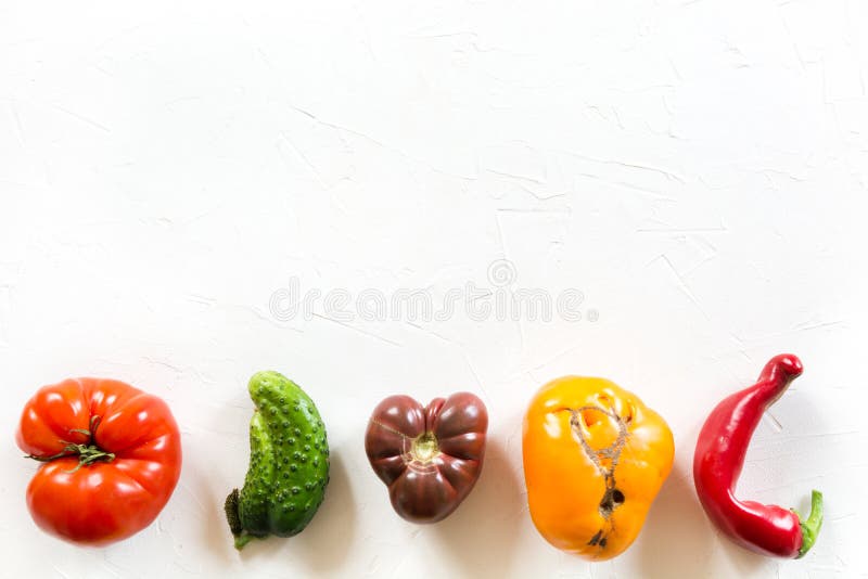 Ugly organic colorful tomato, pepper, cucumber on white concrete table stock photos