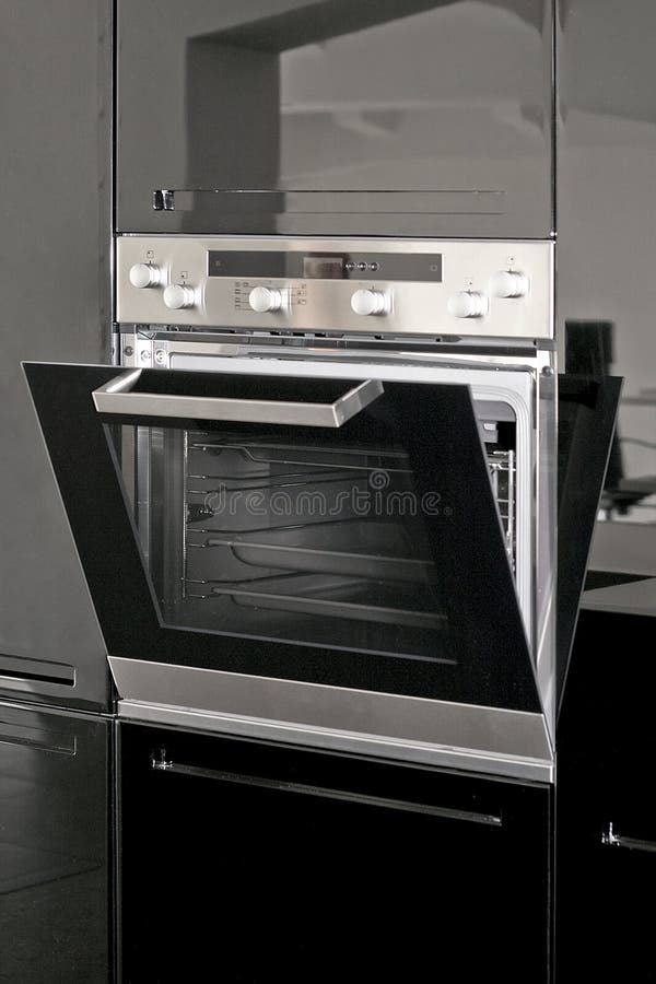 Big silver electric oven in the black kitchen. Big silver electric oven in the black kitchen