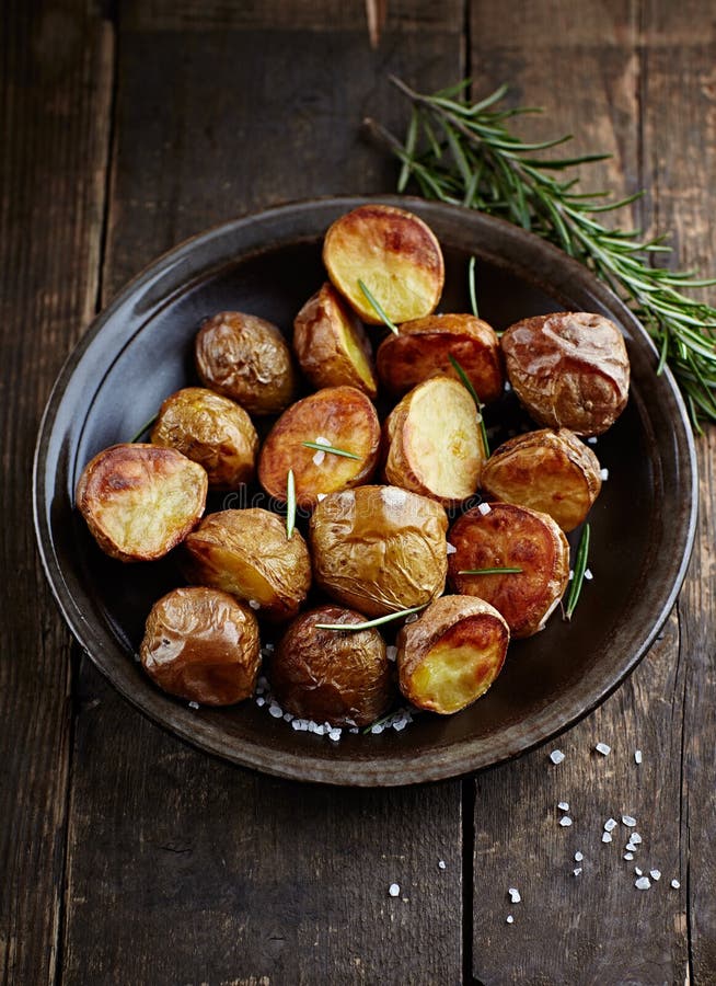 Oven-Baked Potatoes with Sea Salt and Rosemary on a Plate. Oven-Baked Potatoes with Sea Salt and Rosemary on a Plate