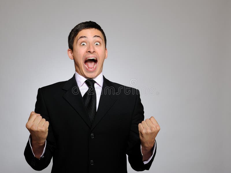 Expressions - Young handsome business man screaming of joy and luck. studio shot. Expressions - Young handsome business man screaming of joy and luck. studio shot