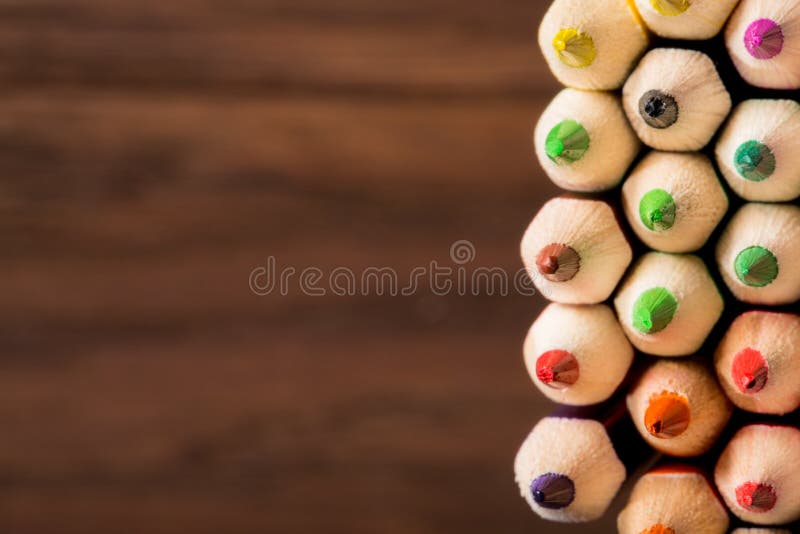 Tips of coloring pencils over a brown textured background. shallow depth of field. Wooden background and wooden pencils. Painting and drawing. Art and design. Tips of coloring pencils over a brown textured background. shallow depth of field. Wooden background and wooden pencils. Painting and drawing. Art and design.