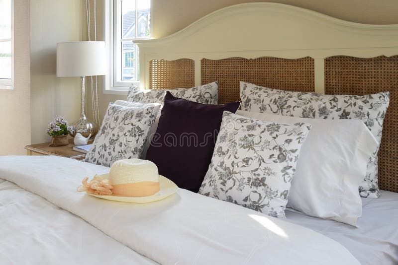 Uitstekend slaapkamerbinnenland met bloemhoofdkussens en decoratieve schemerlamp royalty-vrije stock fotografie Uitstekend slaapkamerbinnenland met bloemhoofdkussens en decoratieve schemerlamp royalty-vrije stock fotografie
