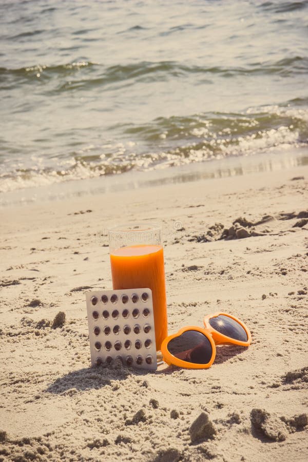 Uitstekende foto, Medische pillen, wortelsap en zonnebril bij strand, vitamine A en mooie, duurzame tan royalty-vrije stock foto's Uitstekende foto, Medische pillen, wortelsap en zonnebril bij strand, vitamine A en mooie, duurzame tan royalty-vrije stock foto's