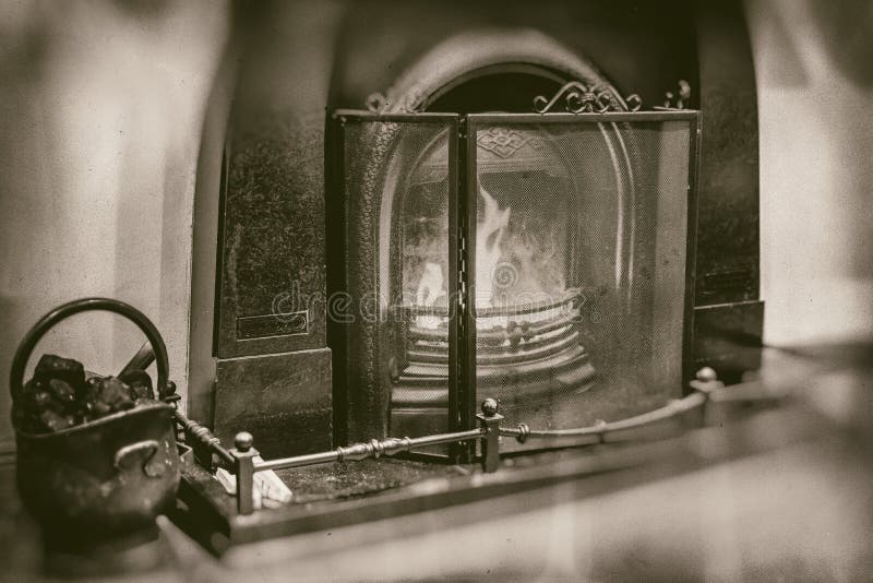 Uitstekende open haard met marmeren het ijzer zwarte emmer van het omgevingshoekje bij de haard met steenkool in retro sepia stij royalty-vrije stock foto Uitstekende open haard met marmeren het ijzer zwarte emmer van het omgevingshoekje bij de haard met steenkool in retro sepia stij royalty-vrije stock foto