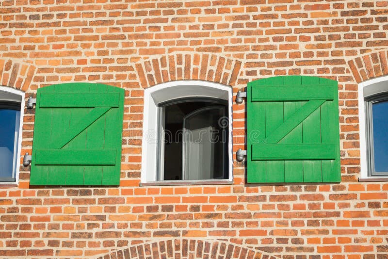 Uitstekende rode bakstenen muur en open venster met groene houten blinden stock afbeelding Uitstekende rode bakstenen muur en open venster met groene houten blinden stock afbeelding