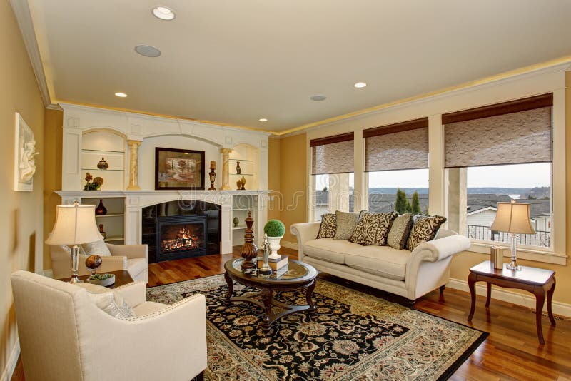 Excellent living room with decorative rug, white furniture and a fireplace. Excellent living room with decorative rug, white furniture and a fireplace.