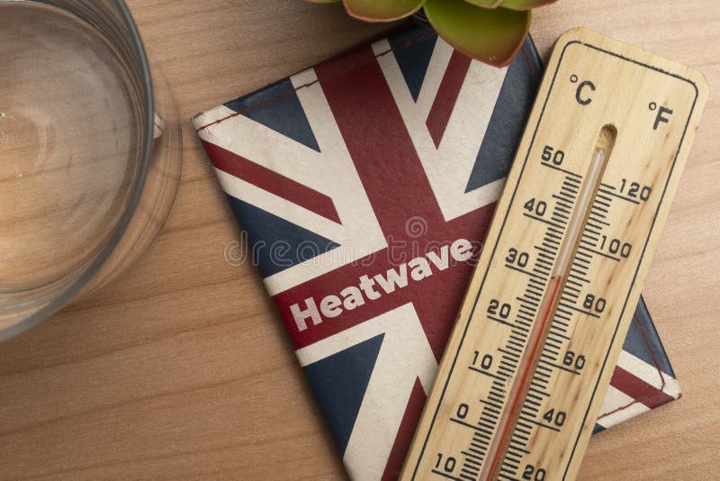 Uk heatwave concept: leather wallet with union jack flag and a thermometer on a wooden table