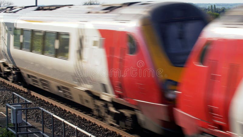 Uk train railroad next to rapeseed field in bloom day view in england. spring railway landscape