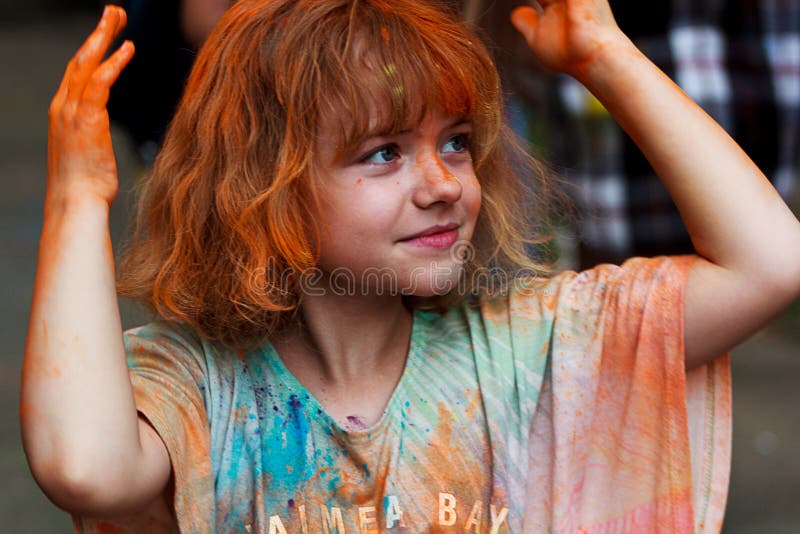 Ukraine, Berdychiv - July 26, 2019: portrait of a little red-haired girl, painted with colorful paints, who has fun and plays. Ukraine, Berdychiv - July 26, 2019: portrait of a little red-haired girl, painted with colorful paints, who has fun and plays.